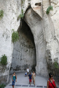 People on rock formation in cave