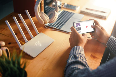 Midsection of man using laptop on table