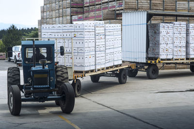 Tractor transporting produce in boxes on factory yard