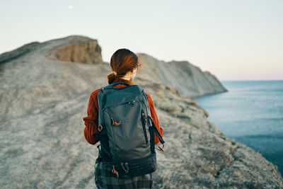 Rear view of man looking at sea against sky