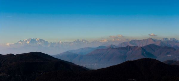 Snow over mountains against sky during sunset