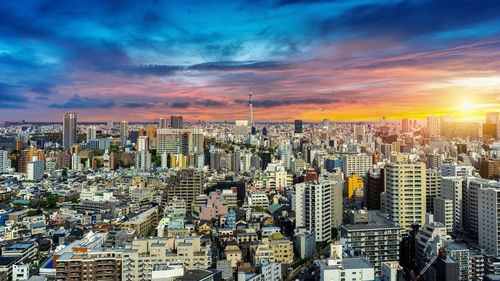 High angle view of modern buildings against sky during sunset