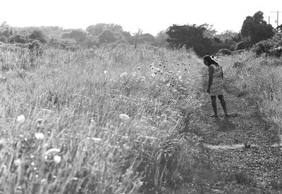 Full length of woman walking on field against sky