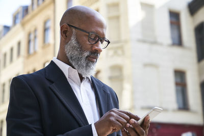 Midsection of man using mobile phone