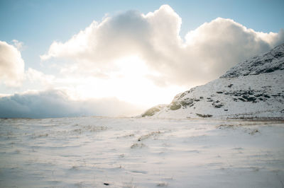 Scenic view of mountains against cloudy sky