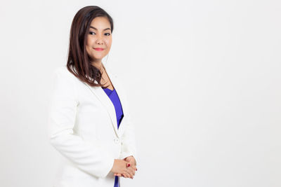 Portrait of a smiling young woman against white background