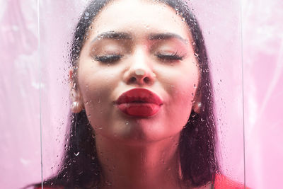 Portrait of woman in wet glass during rainy season