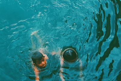 High angle view of siblings swimming in sea