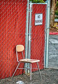 Text on chair against brick wall