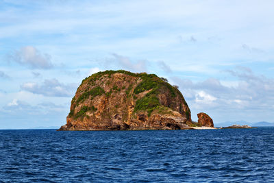 Rock formation in sea against sky