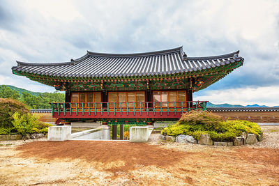 Traditional house on field against sky