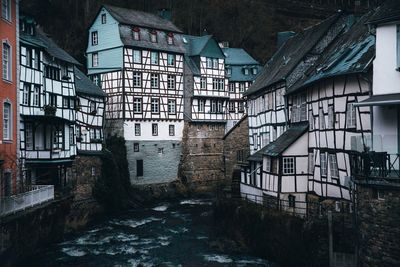 Moody winter scene from monschau germany with historic half timbered buildings lining the river. 