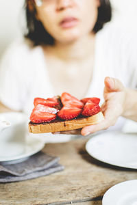 Midsection of a woman with bread on table