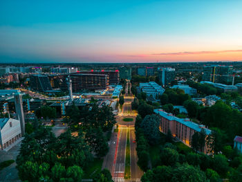 High angle view of illuminated cityscape against sky during sunset