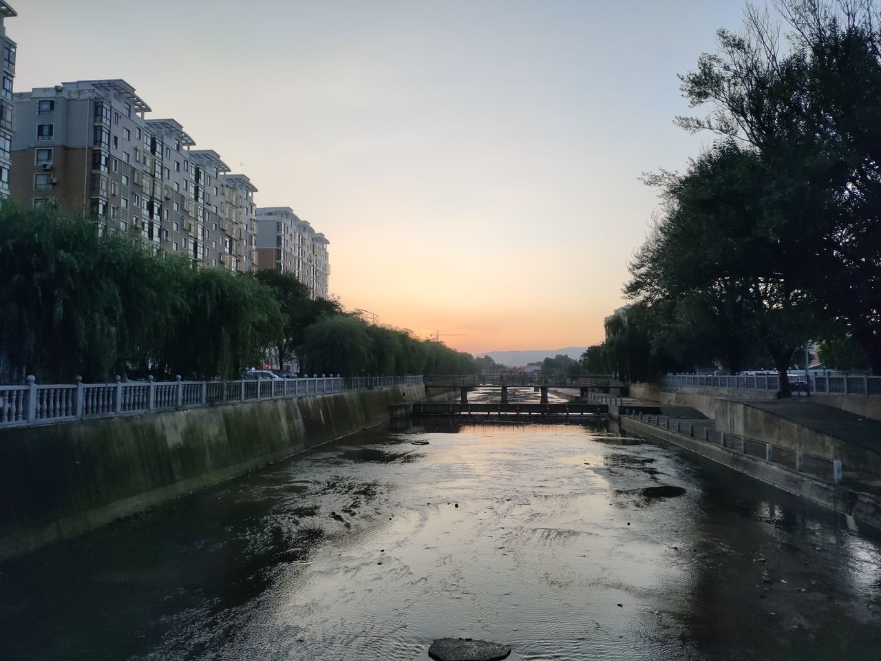 SCENIC VIEW OF RIVER BY BUILDINGS AGAINST SKY