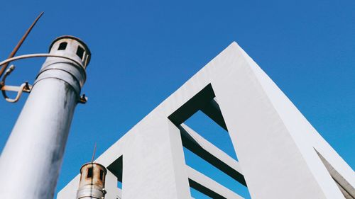 Low angle view of communications tower against clear blue sky