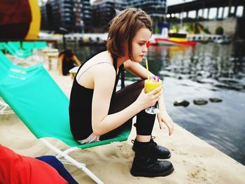 Young woman sitting on boat at lake