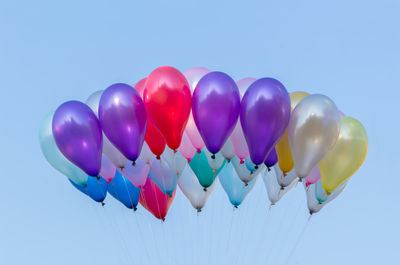 Low angle view of colorful balloons against clear sky
