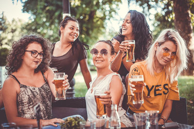 Portrait of a smiling young woman with drinking glasses