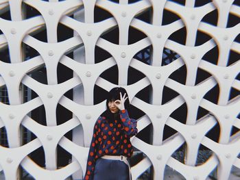 Portrait of woman standing against wall