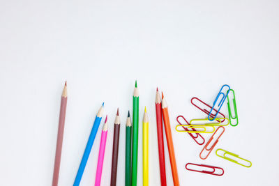 High angle view of colored pencils against white background