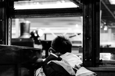 Rear view of woman sitting on bench