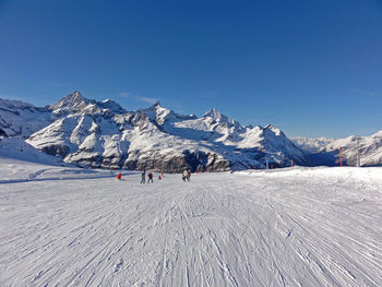 Snow-covered ground with mountains in background