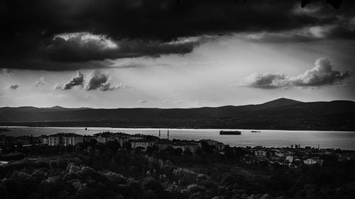 Scenic view of river and mountains against cloudy sky