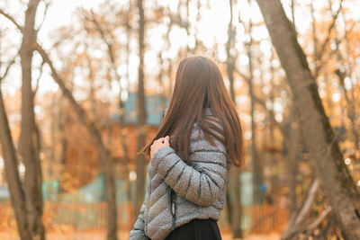 Rear view of woman standing in forest