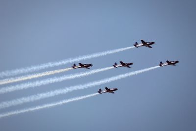 Low angle view of airshow against sky