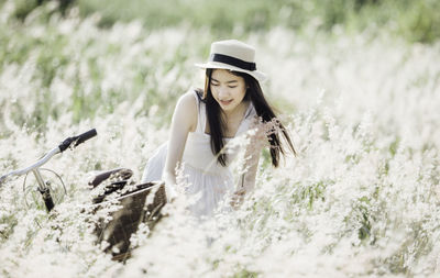 Young woman by bicycle and plants