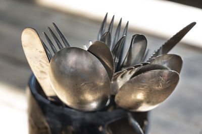 Close-up of eating utensils in container on table