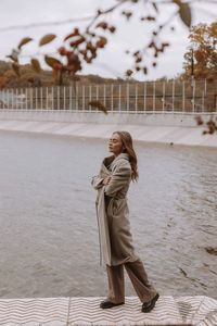 Rear view of woman standing against river