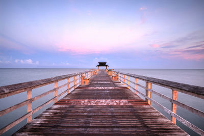 Pier over sea against sky during sunset