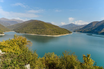 Scenic view of lake by mountains against sky