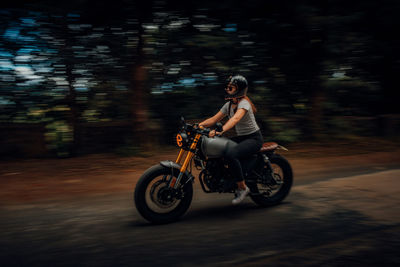 Side view of man riding motorcycle on road