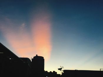 Low angle view of silhouette buildings against dramatic sky