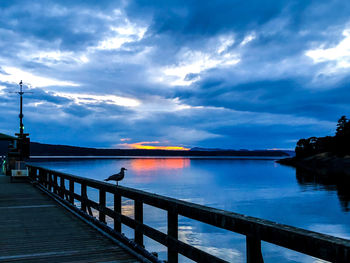 Pier over sea against sky during sunset