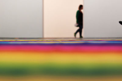 Blurred motion of people standing on multi colored floor