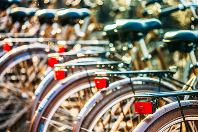 Close-up of bicycles parked in row at city