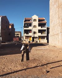 Rear view of man on building against sky