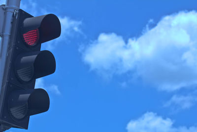 Low angle view of road signal against blue sky