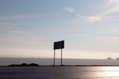 Lifeguard hut on beach against sky during sunset