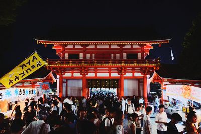 Crowd at illuminated temple at night