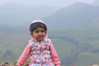 Portrait of smiling girl against mountains