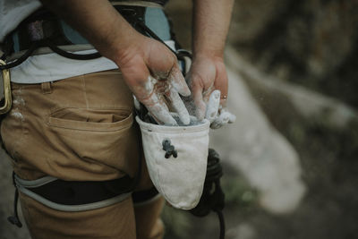 Rear view of man taking sports chalk from bag