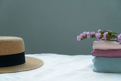 Close-up of white flowers in vase on table against wall