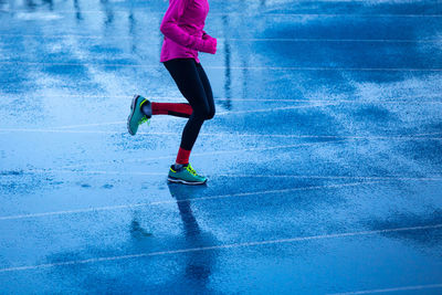 Low section of man running on snow