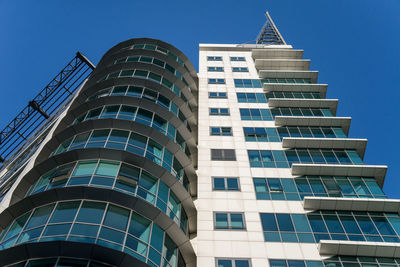 Low angle view of modern building against clear blue sky