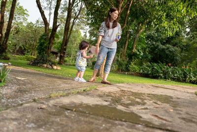 Woman with daughter standing in park